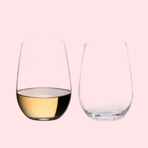 Two wine glasses, one filled with white wine, on a white background