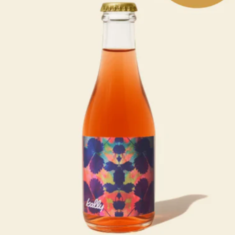 Bottle of pink juice with a colorful label on a beige background