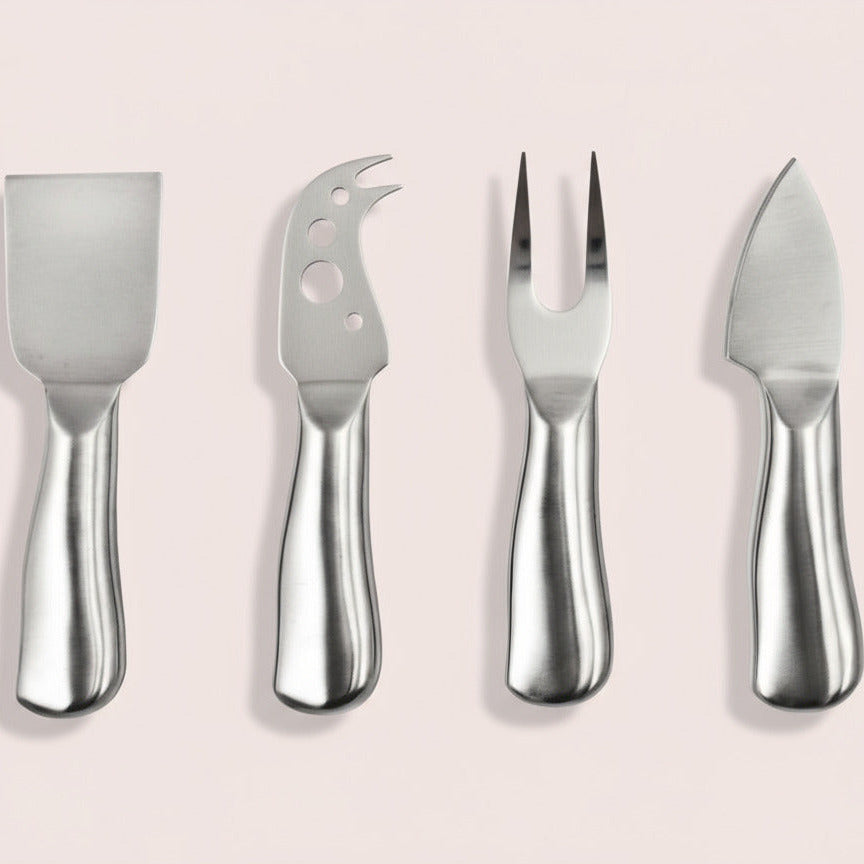Set of four stainless steel cheese tools on a white background