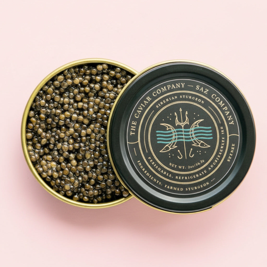 Open tin of Siberian Sturgeon caviar with 'The Caviar Company' branding on a pink background