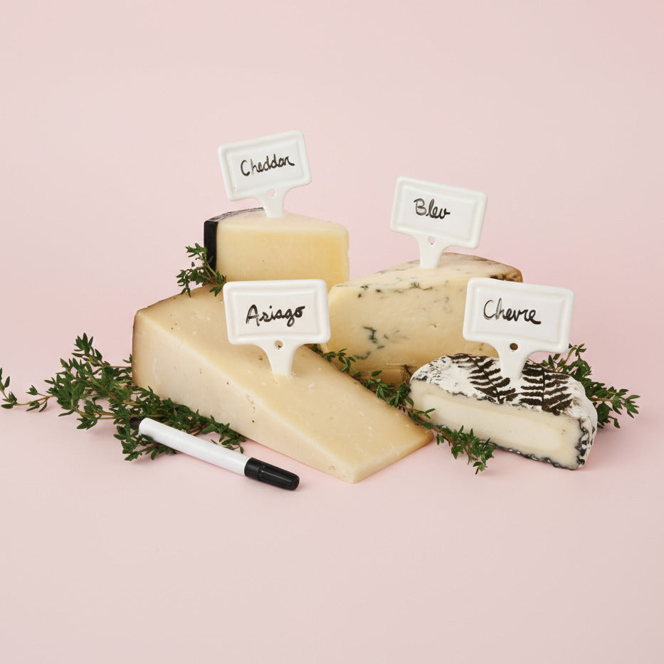 Assorted types of cheese with labels on a white background